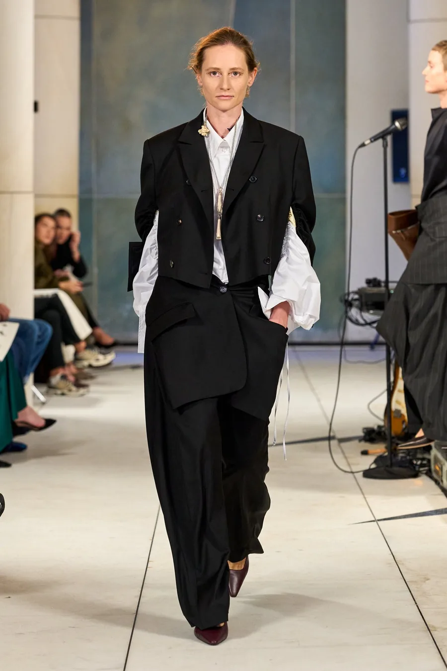 SHOWstudio, Litkovska S/S 27 STRICHA: Model in schwarzem Anzug und weißem Hemd auf dem Laufsteg